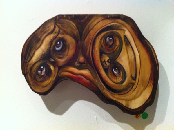 Bradley Messer painting, using the knots in the wood to form eyes